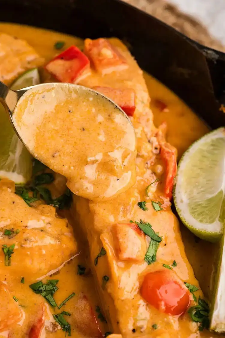 Close-up of 30 Minute Coconut Curry Salmon in a bowl with cilantro, showcasing its rich, creamy sauce and tender fish.