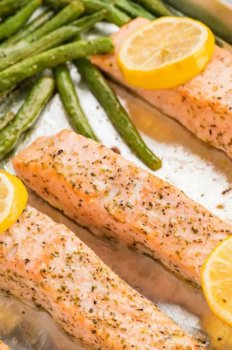 Sheet Pan Salmon with Lemon and Herbs, roasted with potatoes and green beans, fresh from the oven on a baking sheet.