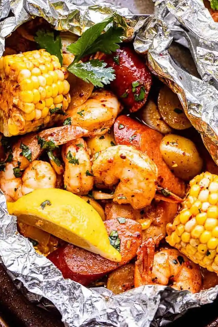Grilled Shrimp Boil in Foil Packets, open to reveal seasoned shrimp, corn, potatoes, and sausage.