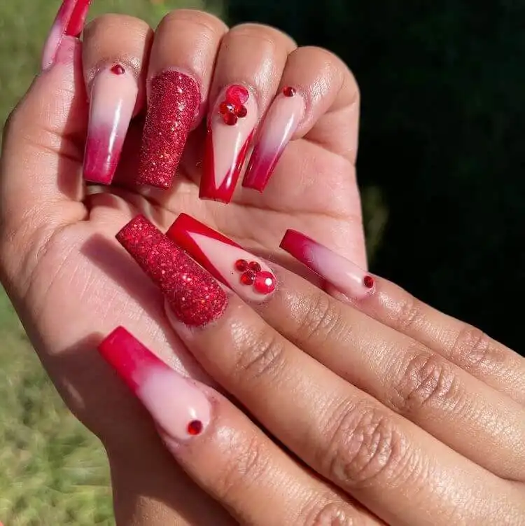 Long red coffin acrylic nails featuring red French tips and a sophisticated black swirl design.