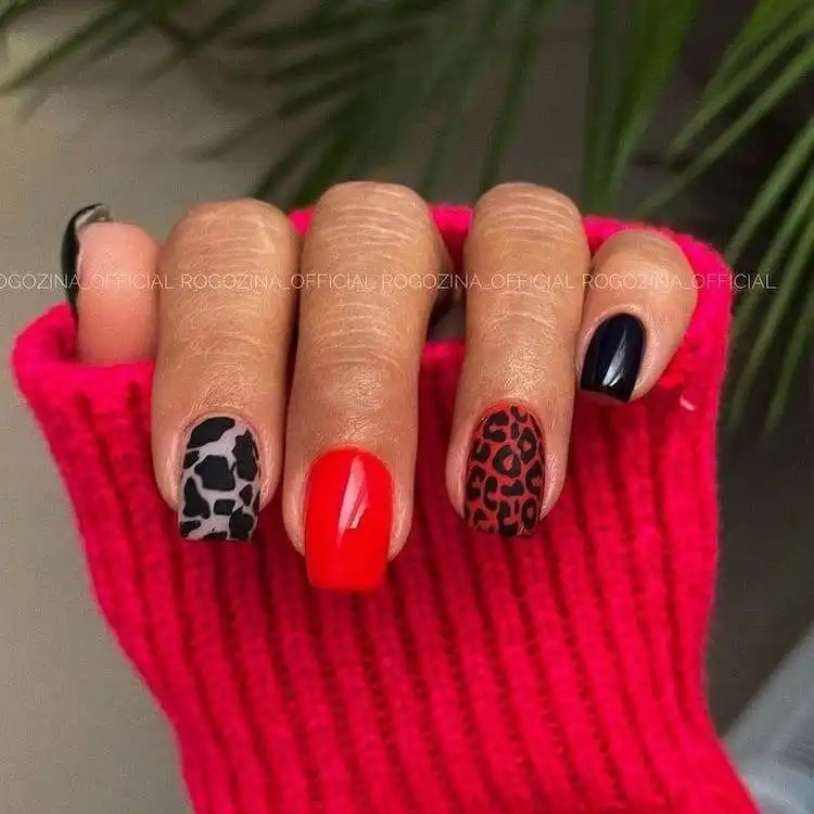 Shimmering red coffin acrylic nails with a modern red French tip on the index finger, combining classic with contemporary.