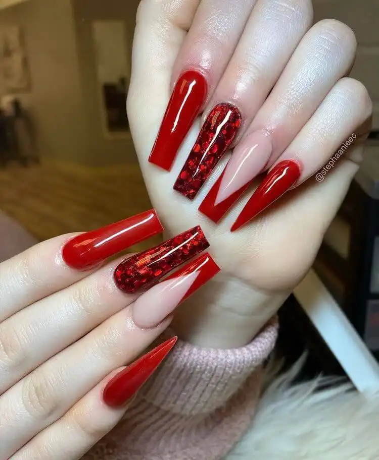 Lovely red acrylic nails adorned with hearts, rhinestones, and sweet details, perfect for Valentine's Day or a romantic feel.