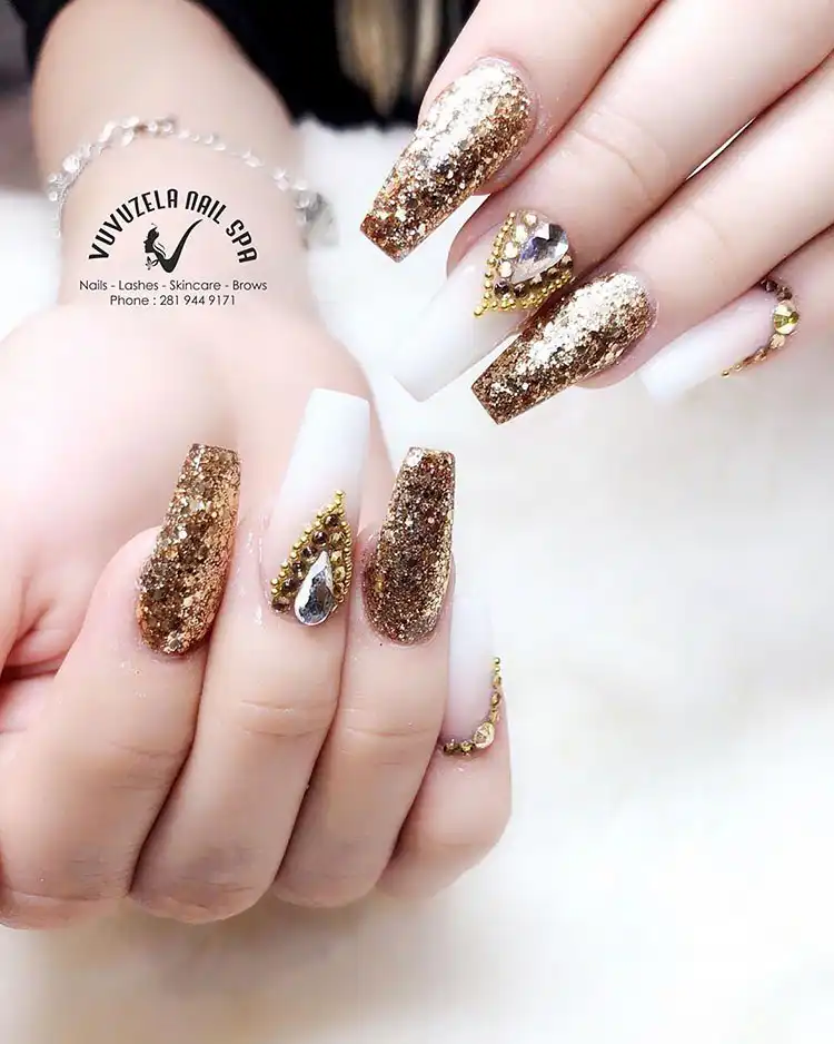Stunning Blue Nail Designs - Perfect Winter Nail Design Ideas 12 Glamorous White and Gold Nails with abundant glitter and rhinestones, perfect for festive winter events and stunning blue nail designs.