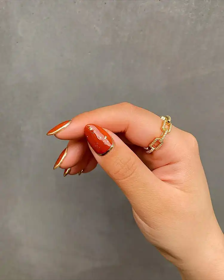 Stunning Blue Nail Designs - Perfect Winter Nail Design Ideas 16 Warm Burnt Orange and Gold nails, a beautiful color scheme for winter, adaptable for stunning blue nail designs.