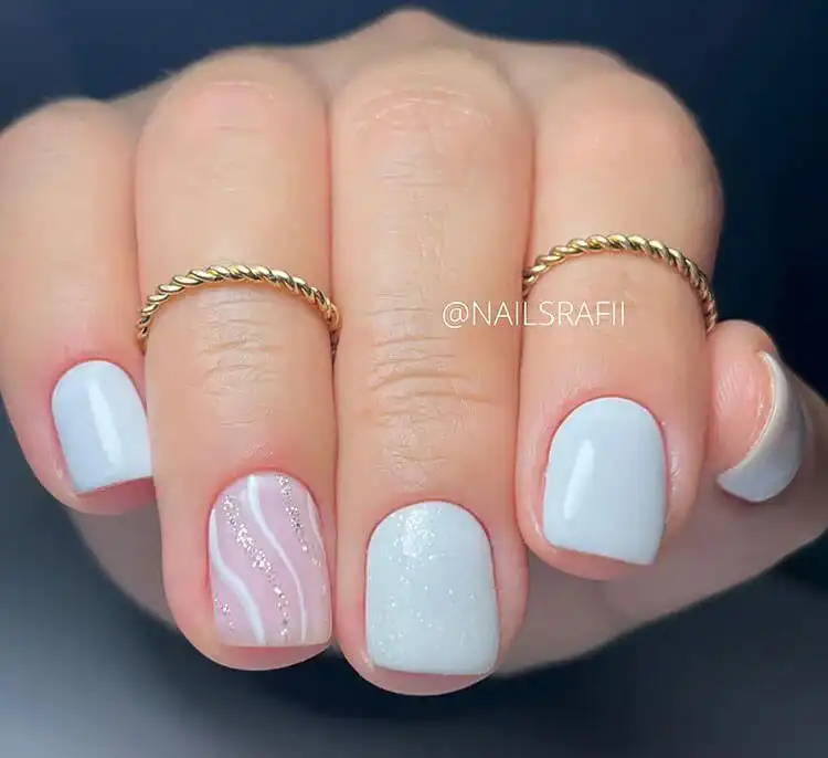 Stunning Blue Nail Designs - Perfect Winter Nail Design Ideas 3 Short Ice Queen Nails with a white base and silver glitter, subtle yet sophisticated winter nail design ideas.