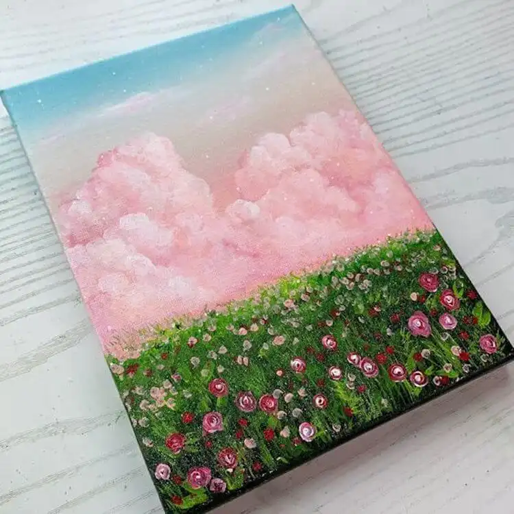 Ethereal acrylic pink cloud painting, with soft pink hues dominating a dreamy sky above a rose field.