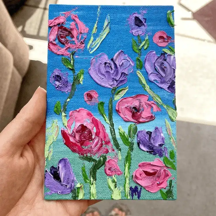 Close-up acrylic painting of a detailed red rose, highlighting intricate petals and rich color on canvas.