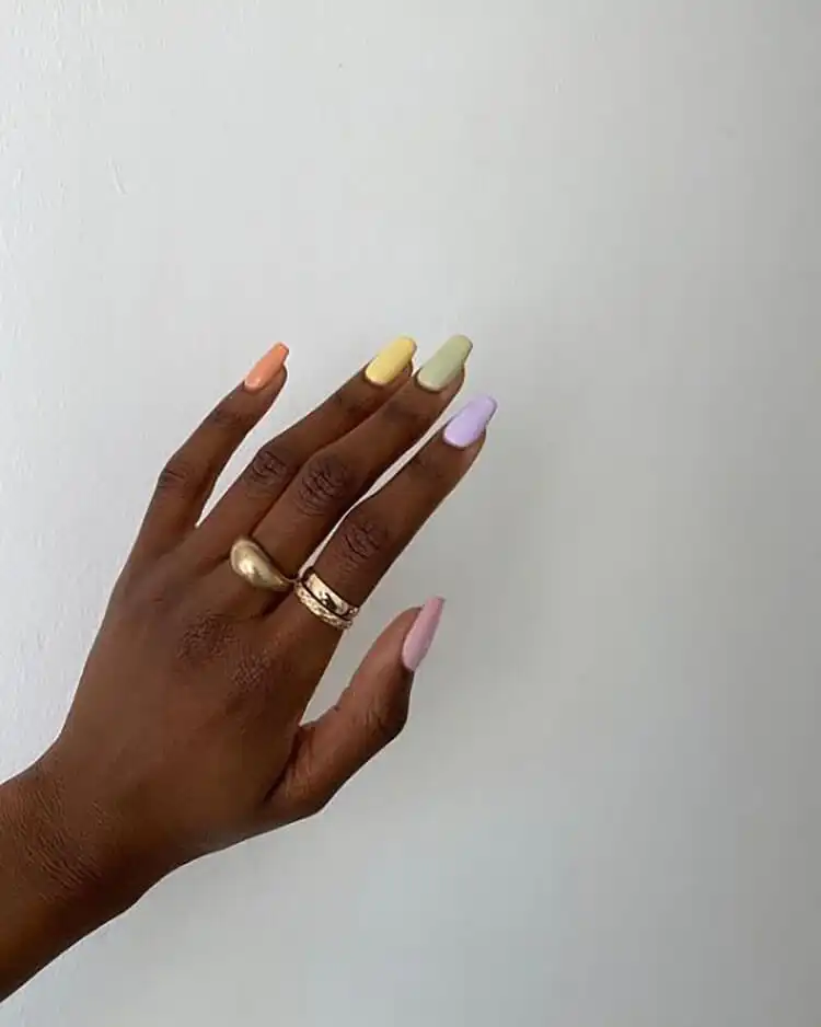Soft pastel almond nails featuring light pink and purple hues on dark skin, a top choice for The Best Nail Designs for Dark Skin Women - Brown Acrylic Nails