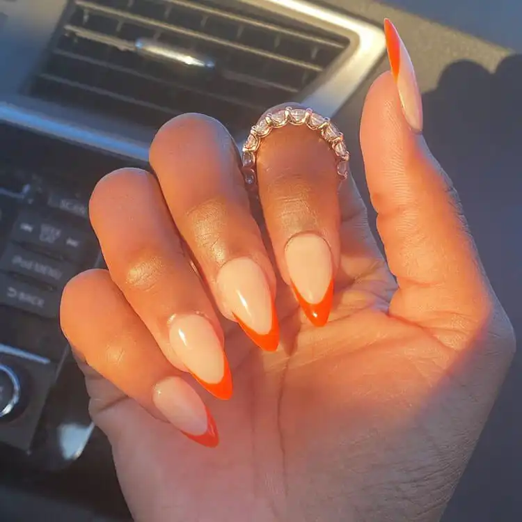 Classic French tip manicure with bold red tips on dark skin, a modern twist from The Best Nail Designs for Dark Skin Women - Brown Acrylic Nails