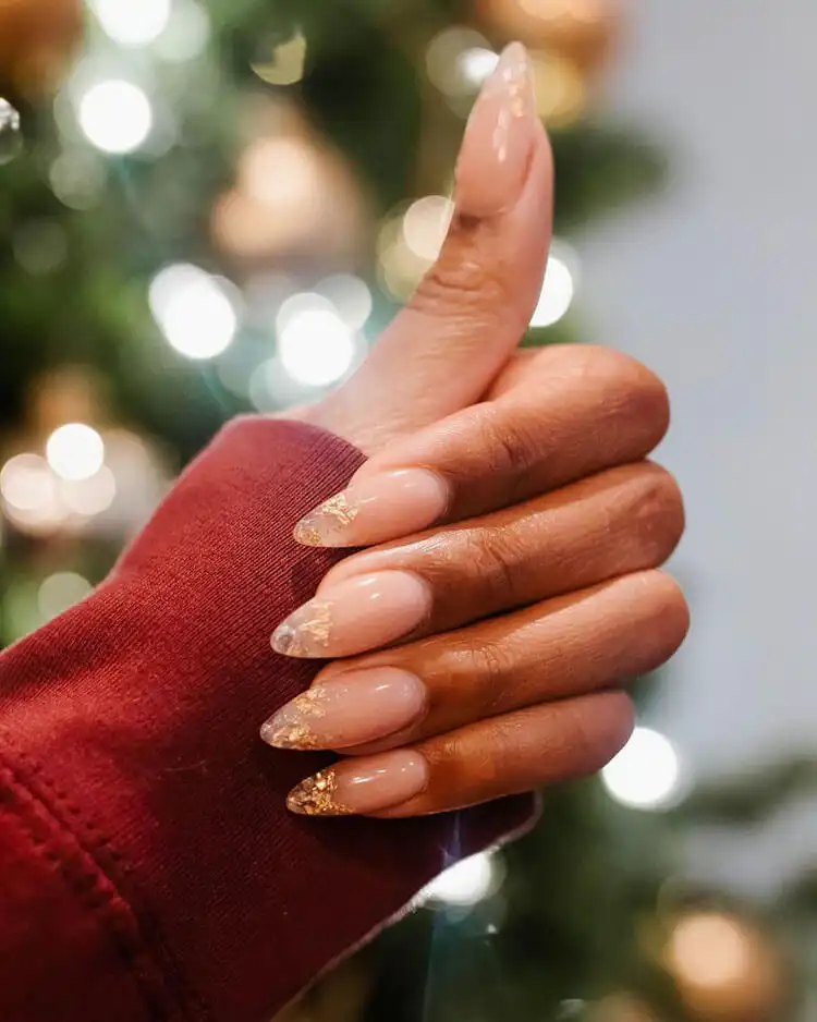 Stiletto nails with luxurious gold flake tips against a nude base on dark skin, part of The Best Nail Designs for Dark Skin Women - Brown Acrylic Nails collection
