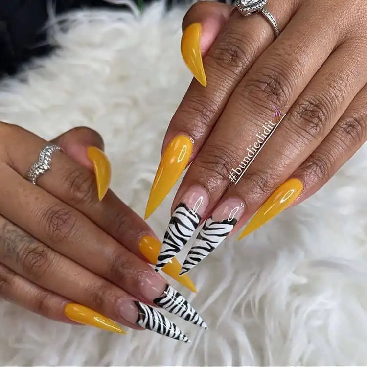Bold zebra stripe pattern on almond-shaped nails against dark skin, a striking option in The Best Nail Designs for Dark Skin Women - Brown Acrylic Nails