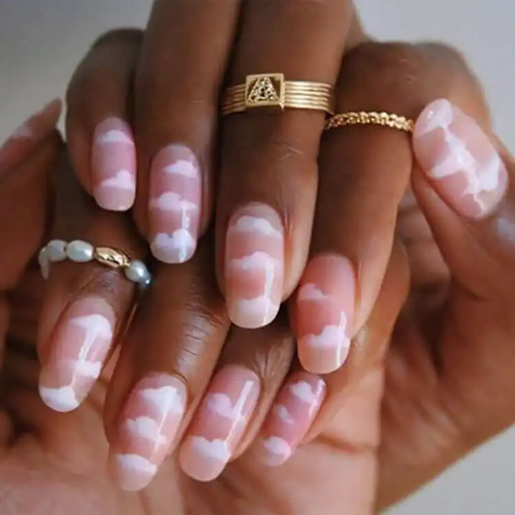 Dreamy fluffy cloud nail design with white clouds on a blue background on dark skin, a whimsical choice from The Best Nail Designs for Dark Skin Women - Brown Acrylic Nails