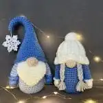 Two tiny crocheted gnome ornaments, one with a green hat and white beard, the other with a red hat and grey beard, ideal for holiday trees.