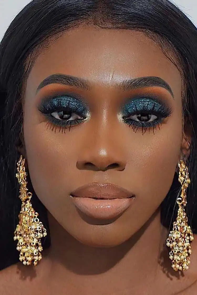 Close-up of eye makeup featuring shimmering metallic eyeshadow for a glamorous, festive look.