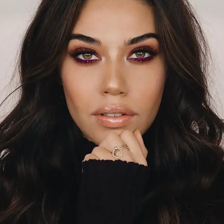 Eye makeup with striking blue glittery eyeshadow contrasted with warm orange tones.