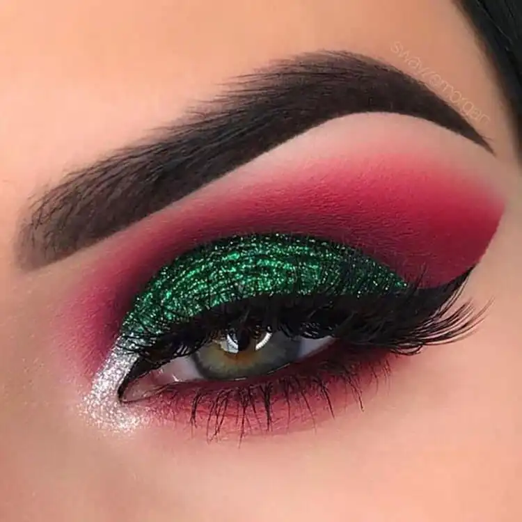 Festive eye makeup featuring vibrant green glitter eyeshadow with a silver inner corner highlight.