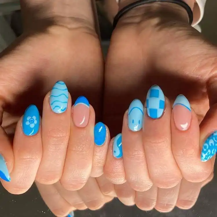 Blue ombre nails with intricate butterfly wing patterns, a wonderful blue nail design that is bold and classic.