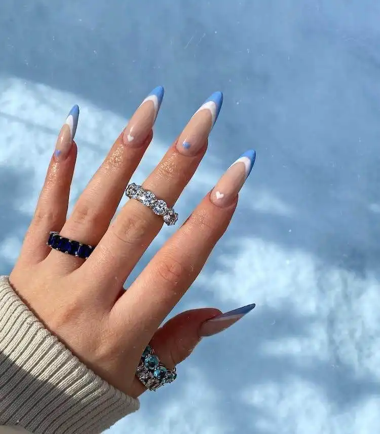Feminine blue and white heart nail design with double French tips, a wonderful blue nail design that is classic and bold.