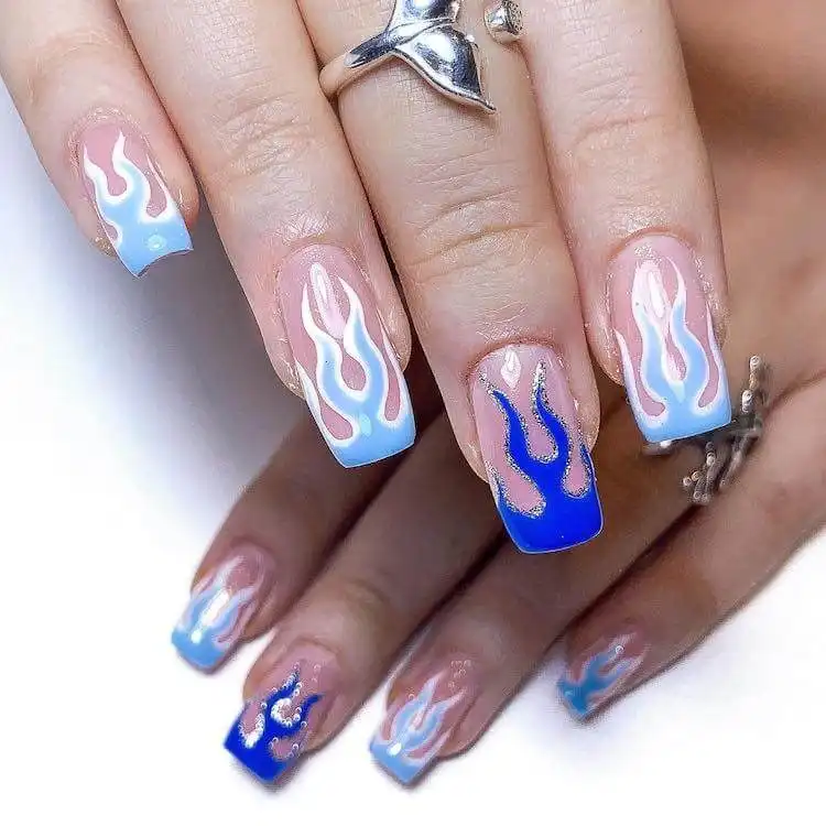 Edgy blue flame nail design on elongated nails, a wonderful blue nail design that is bold and classic.