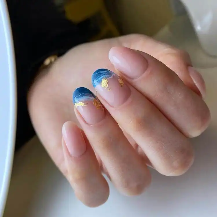 Ocean blue nails with gold wave accents, a wonderful blue nail design featuring natural elements that are bold and classic.