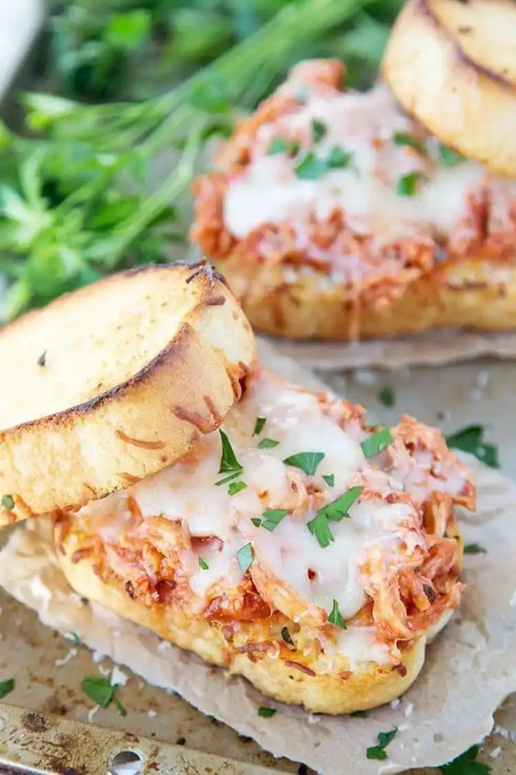 A shredded chicken parmesan sandwich on crispy Texas toast, filled with saucy chicken and gooey melted cheese.