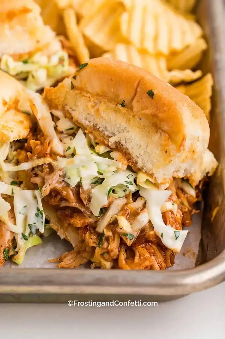 Mini BBQ chicken sliders piled high with saucy rotisserie chicken, crispy bacon, and served on toasted Hawaiian rolls.